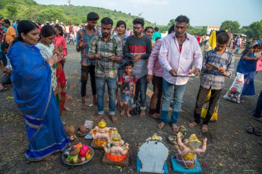 Amravati, Maharashtra, Hindistan - 23 Eylül 2018: Tanımlanamayan inançlı insanlar Ganesh festivali sırasında suya batmadan önce Hindu Tanrısı Ganesha 'ya dua ettiler. Ganesh Chaturthi bir annua.