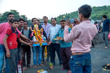 Amravati, Maharashtra, Hindistan - 23 Eylül 2018: Tanımlanamayan inançlı insanlar Ganesh festivali sırasında suya batmadan önce Hindu Tanrısı Ganesha 'ya dua ettiler. Ganesh Chaturthi bir annua.