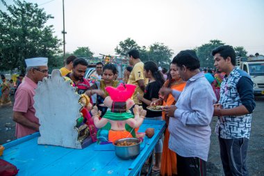 Amravati, Maharashtra, Hindistan - 23 Eylül 2018: Tanımlanamayan inançlı insanlar Ganesh festivali sırasında suya batmadan önce Hindu Tanrısı Ganesha 'ya dua ettiler. Ganesh Chaturthi bir annua.