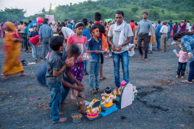 Amravati, Maharashtra, Hindistan - 23 Eylül 2018: Tanımlanamayan inançlı insanlar Ganesh festivali sırasında suya batmadan önce Hindu Tanrısı Ganesha 'ya dua ettiler. Ganesh Chaturthi bir annua.