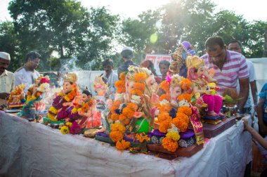 Amravati, Maharashtra, Hindistan - 23 Eylül 2018: Tanımlanamayan inançlı insanlar Ganesh festivali sırasında suya batmadan önce Hindu Tanrısı Ganesha 'ya dua ettiler. Ganesh Chaturthi bir annua.