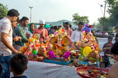 Amravati, Maharashtra, Hindistan - 23 Eylül 2018: Tanımlanamayan inançlı insanlar Ganesh festivali sırasında suya batmadan önce Hindu Tanrısı Ganesha 'ya dua ettiler. Ganesh Chaturthi bir annua.