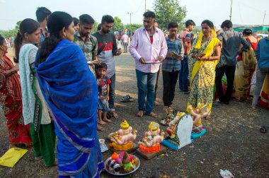 Amravati, Maharashtra, Hindistan - 23 Eylül 2018: Tanımlanamayan inançlı insanlar Ganesh festivali sırasında suya batmadan önce Hindu Tanrısı Ganesha 'ya dua ettiler. Ganesh Chaturthi bir annua.