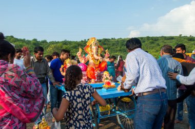 Amravati, Maharashtra, Hindistan - 23 Eylül 2018: Tanımlanamayan inançlı insanlar Ganesh festivali sırasında suya batmadan önce Hindu Tanrısı Ganesha 'ya dua ettiler. Ganesh Chaturthi bir annua.