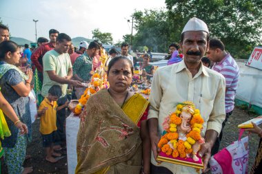 Amravati, Maharashtra, Hindistan - 23 Eylül 2018: Ganesh festivali sırasında Hindu Tanrısı Ganesha 'yı suya batırılmadan önce taşıyan tanımlanamayan inançlı insanlar. Yıllık festival.