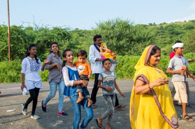 Amravati, Maharashtra, Hindistan - 23 Eylül 2018: Ganesh festivali sırasında Hindu Tanrısı Ganesha 'yı suya batırılmadan önce taşıyan tanımlanamayan inançlı insanlar. Yıllık festival.