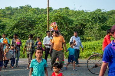 Amravati, Maharashtra, Hindistan - 23 Eylül 2018: Ganesh festivali sırasında Hindu Tanrısı Ganesha 'yı suya batırılmadan önce taşıyan tanımlanamayan inançlı insanlar. Yıllık festival.