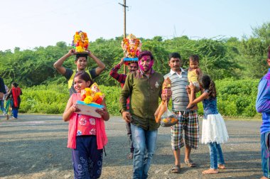 Amravati, Maharashtra, Hindistan - 23 Eylül 2018: Ganesh festivali sırasında Hindu Tanrısı Ganesha 'yı suya batırılmadan önce taşıyan tanımlanamayan inançlı insanlar. Yıllık festival.