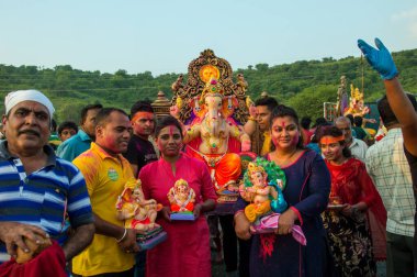 Amravati, Maharashtra, Hindistan - 23 Eylül 2018: Ganesh festivali sırasında Hindu Tanrısı Ganesha 'yı suya batırılmadan önce taşıyan tanımlanamayan inançlı insanlar. Yıllık festival.