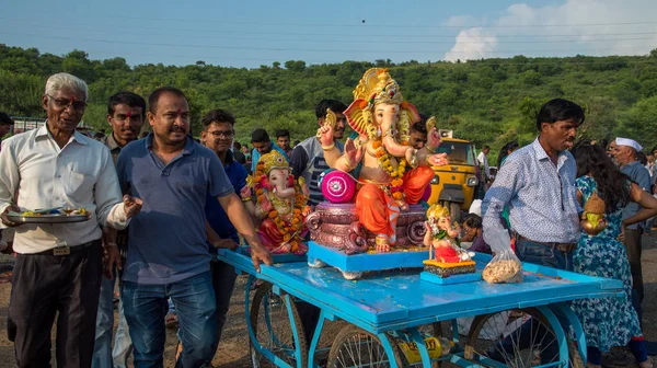 Amravati, Maharashtra, Indien - 23 september 2018: Oidentifierat troget folk som bär på hinduiska guden Ganesha innan nedsänkning nära vattendrag under Ganesh-festivalen. Årlig festival. — Stockfoto