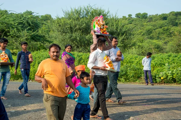 Amravati, Maharashtra, Hindistan - 23 Eylül 2018: Ganesh festivali sırasında Hindu Tanrısı Ganesha 'yı suya batırılmadan önce taşıyan tanımlanamayan inançlı insanlar. Yıllık festival. — Stok fotoğraf