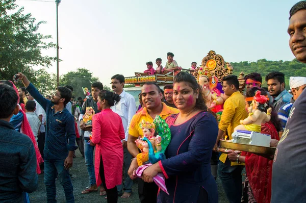 Amravati, Maharashtra, Hindistan - 23 Eylül 2018: Ganesh festivali sırasında Hindu Tanrısı Ganesha 'yı suya batırılmadan önce taşıyan tanımlanamayan inançlı insanlar. Yıllık festival. — Stok fotoğraf