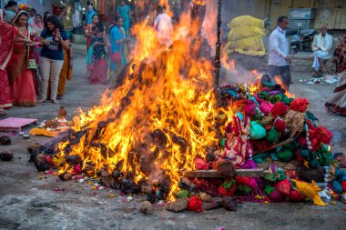 Amravati, Maharashtra, Hindistan, Mart - 1, 2018: Tahta kütüklere ya da hindistan cevizine taparak Holika Dahan 'ı kutlayan kimliği belirsiz insanlar. Holi renk festivali ya da paylaşım festivali olarak da bilinir.