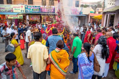 Amravati, Maharashtra, Hindistan, Mart - 1, 2018: Tahta kütüklere ya da hindistan cevizine taparak Holika Dahan 'ı kutlayan kimliği belirsiz insanlar. Holi renk festivali ya da paylaşım festivali olarak da bilinir.