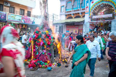 Amravati, Maharashtra, Hindistan, Mart - 1, 2018: Tahta kütüklere ya da hindistan cevizine taparak Holika Dahan 'ı kutlayan kimliği belirsiz insanlar. Holi renk festivali ya da paylaşım festivali olarak da bilinir.