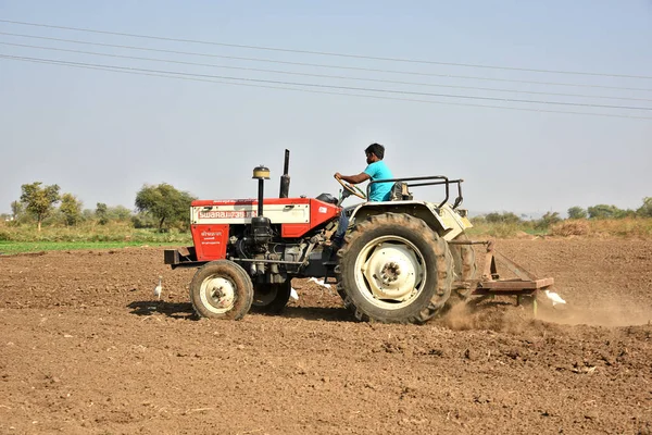 AMRAVATI, MAHARASHTRA, INDIA - 03 FEB 2017: Agricultor no identificado en tractor preparando tierra para siembra con sembradora . — Foto de Stock