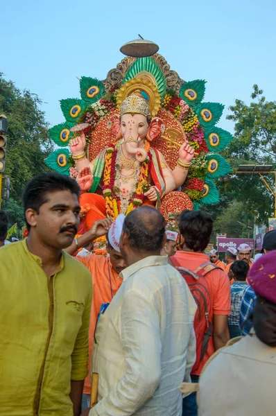 Amravati，Maharashtra，印度- 2018年9月27日：一群身份不明的人携带印度教神Ganesha，在Ganesha节期间与鼓和音乐一起浸入水体。 年度节庆. — 图库照片