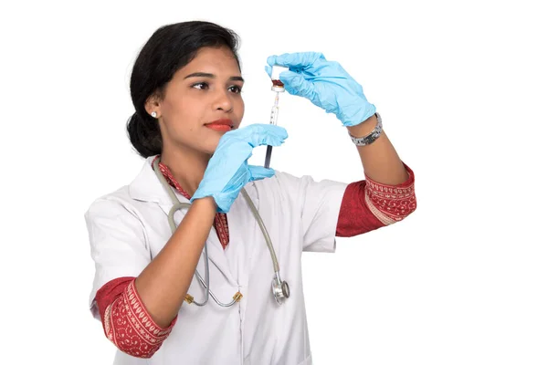 Uma médica com um estetoscópio está segurando uma injeção ou seringa . — Fotografia de Stock