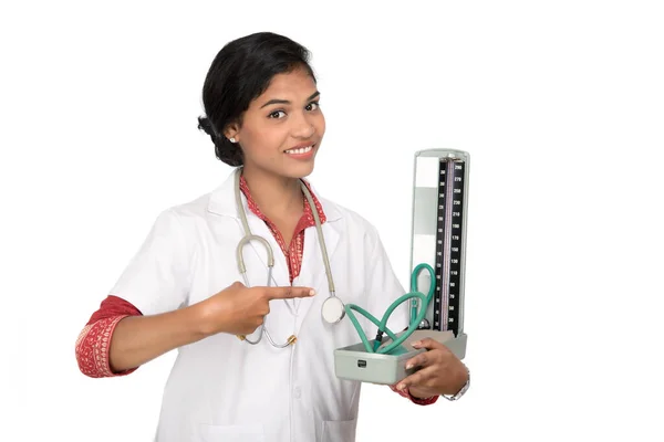 Retrato de uma mulher médica com instrumento de pressão arterial e estetoscópio em fundo branco . — Fotografia de Stock