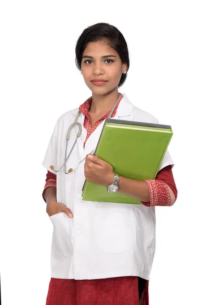 Młoda kobieta lekarz prowadzący książkę ze stetoskopem — Zdjęcie stockowe
