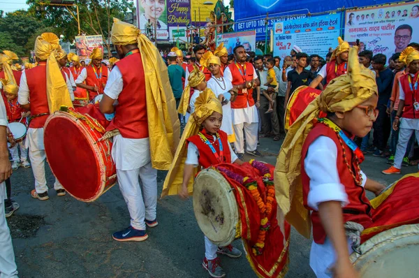 Amravati，Maharashtra，印度- 2018年9月27日：一群身份不明的人携带印度教神Ganesha，在Ganesha节期间与鼓和音乐一起浸入水体。 年度节庆. — 图库照片