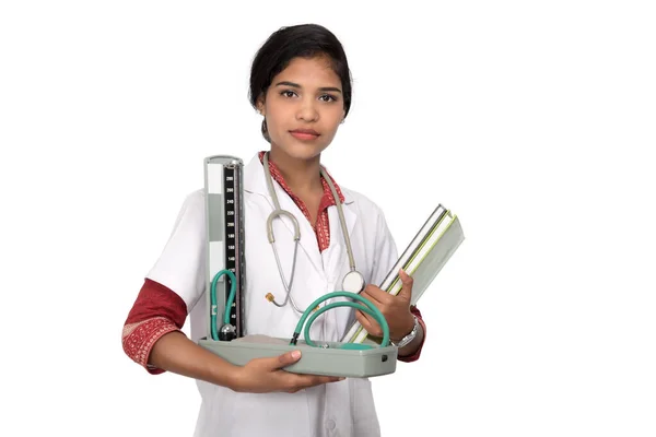 Retrato de uma mulher médica com instrumento de pressão arterial e estetoscópio em fundo branco . — Fotografia de Stock