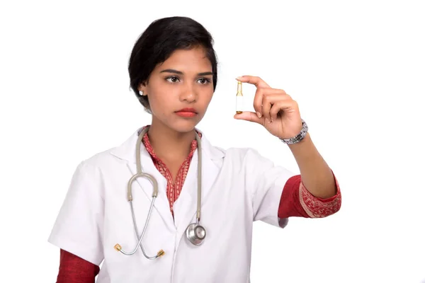 Médica feminina mostrando o tubo de medicina em fundo branco — Fotografia de Stock