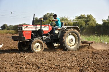 Amravati, Maharashtra, Hindistan - 03 Şubat 2017: Traktördeki tanımlanamayan çiftçi tohum ekmeye hazırlanıyor.