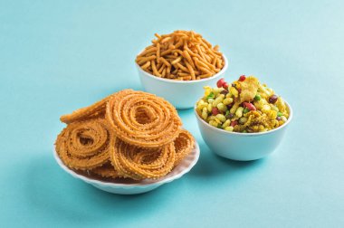 Hint Atıştırması: Mavi arka planda Chakli, chakali veya Murukku ve Besan (Gram unu) Sev ve chivada veya chiwada. Diwali Gıda