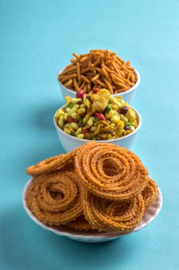 Hint Atıştırması: Mavi arka planda Chakli, chakali veya Murukku ve Besan (Gram unu) Sev ve chivada veya chiwada. Diwali Gıda