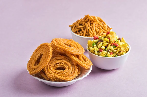 Indischer Imbiss: chakli, chakali oder murukku und besan (Gramm Mehl) sev und chivada oder chiwada auf rosa Hintergrund. Diwali-Essen — Stockfoto