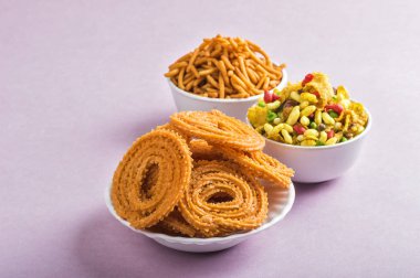 Hint Atıştırması: Chakli, chakali veya Murukku ve Besan (Gram unu) Sev ve chivada veya pembe arka planda chiwada. Diwali Gıda