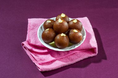 Gulab Jamun, beyaz kasede beyaz peçeteli Hint tatlısı.