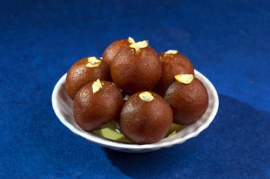 Gulab Jamun, Hint tatlısı, beyaz kâse ve peçeteli kuru patates.