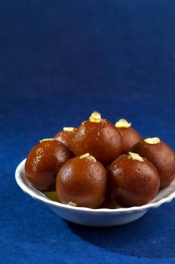 Gulab Jamun, Hint tatlısı, beyaz kâse ve peçeteli kuru patates.