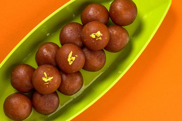 Indian Dessert Gulab Jamun in plate on orange background — Stock Photo, Image