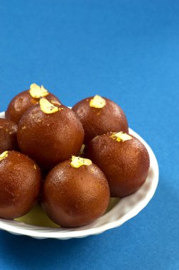 Gulab Jamun, Hint tatlısı, beyaz kâse ve peçeteli kuru patates.