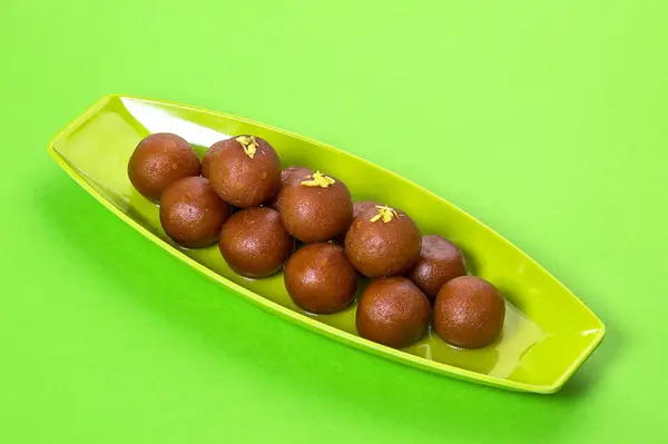 Gulab Jamun en plato sobre fondo verde. Postre indio o plato dulce . — Foto de Stock