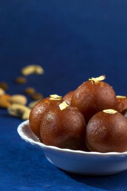 Gulab Jamun, Hint tatlısı, beyaz kâse ve peçeteli kuru patates.