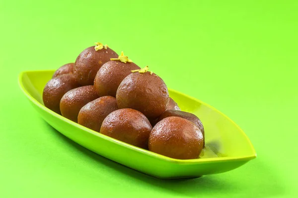 Гулаб Джамун на зеленому фоні. Індійський десерт або солодкий обід. — стокове фото