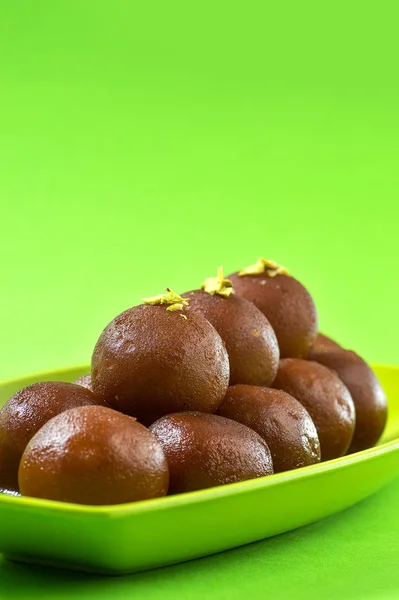 Gulab Jamun in piatto su sfondo verde. Dessert indiano o piatto dolce . — Foto Stock