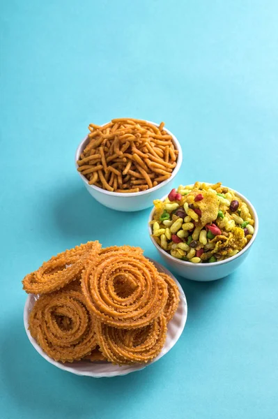 Indischer Imbiss: chakli, chakali oder murukku und besan (Gramm Mehl) sev und chivada oder chiwada auf blauem Hintergrund. Diwali-Essen — Stockfoto