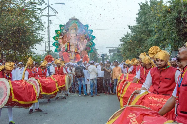 Amravati，Maharashtra，印度- 2018年9月27日：一群身份不明的人携带印度教神Ganesha，在Ganesha节期间与鼓和音乐一起浸入水体。 年度节庆. — 图库照片