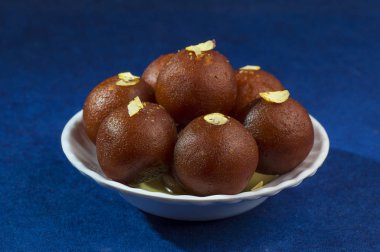 Gulab Jamun, Hint tatlısı, beyaz kâse ve peçeteli kuru patates.