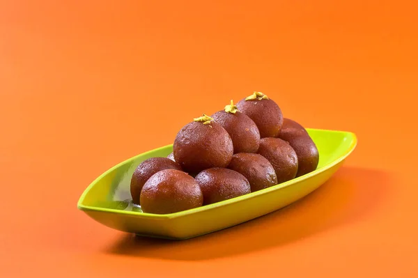 Indisches Dessert Gulab Jamun im Teller auf orangefarbenem Hintergrund — Stockfoto