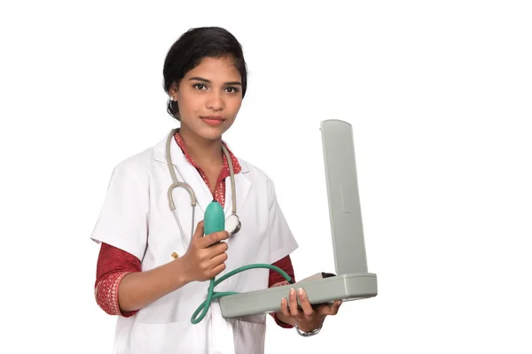 Retrato de uma mulher médica com instrumento de pressão arterial e estetoscópio em fundo branco . — Fotografia de Stock