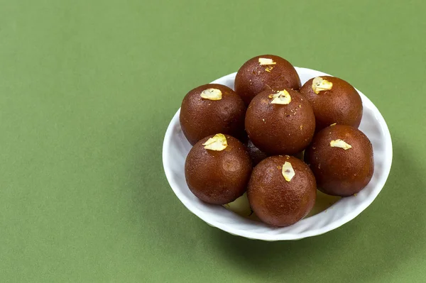 Gulab Jamun, індійський десерт з фістахіо на зеленому тлі. — стокове фото