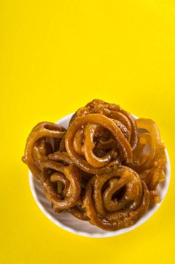 Sarı arka planda Jalebi Hint yemeği