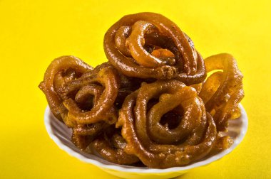 Sarı arka planda Jalebi Hint yemeği