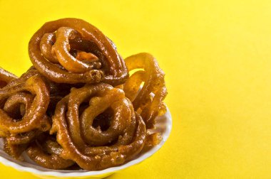 Sarı arka planda Jalebi Hint yemeği